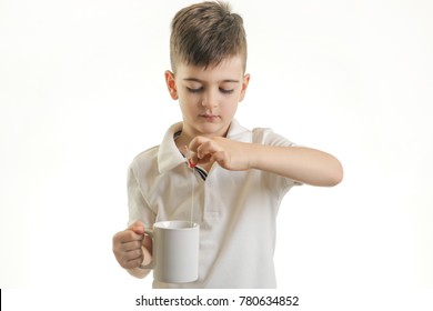 Studio Shot Of Young Boy Making Cup Of Tea - Healthy Eating Habits Concept