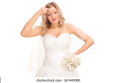 Studio shot of a young bride in a white wedding dress having a headache isolated on white background