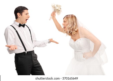 Studio shot of a young bride yelling to the groom and threatening him isolated on white background