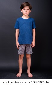 Studio Shot Of Young Cute Boy Against Black Background