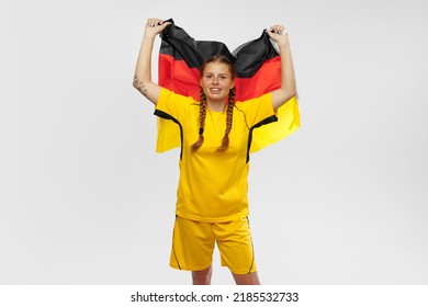 Studio shot of young emotional girl with german national flag supports favorite team isolated over white vackground. Soccer fans emotions, competition, sport, championship concept.