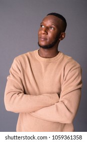 Studio shot of young handsome African man with short hair against gray background - Shutterstock ID 1059361358