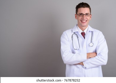 Studio shot of young handsome man doctor against gray background - Shutterstock ID 767878252