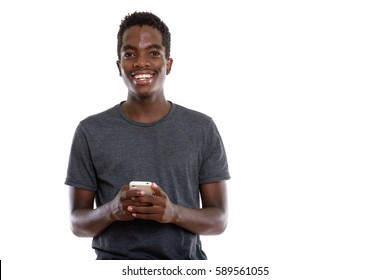 Studio Shot Of Young Hpapy Black African Teenage Boy Smiling While Holding Mobile Phone