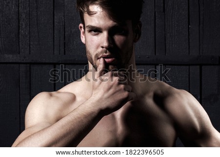 Studio shot of young man looking at the camera. Handsome guy with confident face. Mens sexuality or attraction and charisma