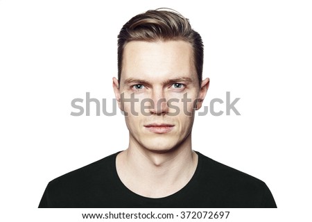 Studio shot of young man looking at the camera. Isolated on white background. Horizontal format, he has a serious face, he is wearing a black T-shirt.