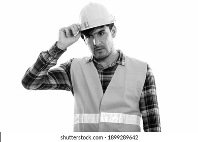 Studio Shot Of Young Persian Man Construction Worker Thinking While Looking Down