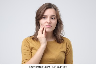 Studio Shot Of Young Woman With Tooth Pain.