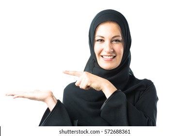 Studio Shot Of Young Woman Wearing Traditional Arabic Clothing. She's Holding Her Hand To The Side So You Can Photoshop In Your Own Content, Like A Product Box Or Something Similar