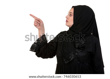 studio shot of young woman wearing traditional arabic clothing. she's holding her hand to the side