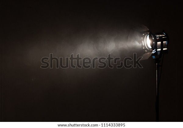 Studio\
spotlight using for background production film . silhouette blurred\
led lights with smoke in dark room . electric tools set for\
photography , video maker ,\
cinematography
