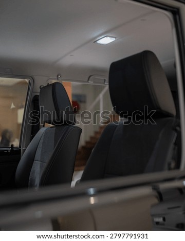 Studio style shot inside a parked car highlighting front seats dashboard and calm cabin lighting