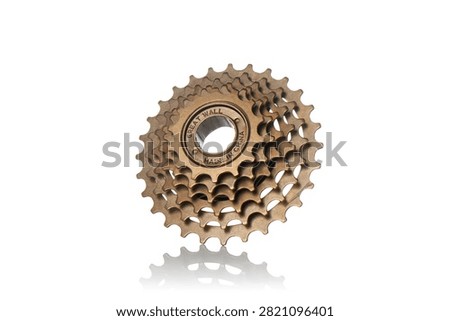 Studio three quarter perspective view of bronze multi speed bicycle freewheel cassette featuring steel gear sprockets, threaded hub core mechanism, polished metallic texture, and soft bottom reflection on isolated white background showcasing cycling drivetrain components.