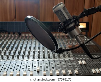 A Studio Vocal Microphone Over A Mixing Board Console