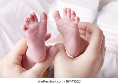 Studio-shot Of A Mother Showing Newborn Baby Feet.

Hands Holding Baby Feet.