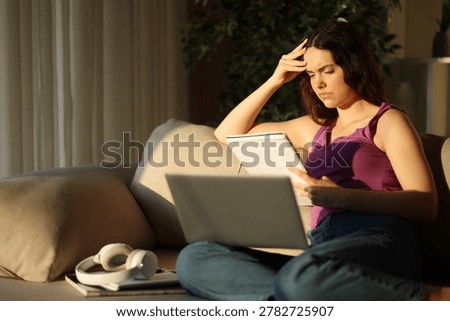 Studious student learning reading notes sitting on a couch at home