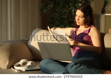 Studious student at sunset memorizing notes elearning sitting on a couch at home