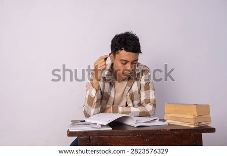 A studious young individual deeply engaged in reading and notes.