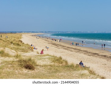 Studland Bay, Dorset, England - March 27, 2022: People enjoying Knoll Beach during a spring day on the south coast of England.