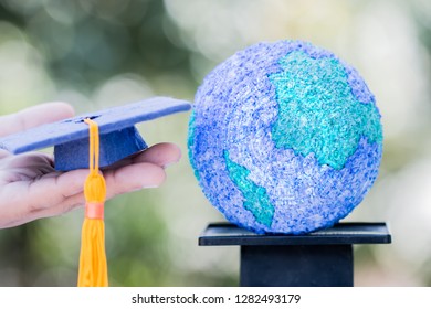 Study Abroad International Graduated Ideas. Education World Or Graduation Hat On Hands With Paper Mache Craft Earth Globe On Scales Balance. Concept Of Congratulation To Graduate University To Success