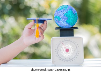 Study Abroad International Graduated Ideas. Education World Or Graduation Hat On Hands With Paper Mache Craft Earth Globe On Scales Balance. Concept Of Congratulation To Graduate University To Success