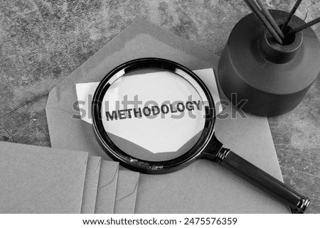 Study or activity concept. The word methodology written through a magnifying glass on a piece of paper sticking out of an envelope. Classified information