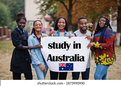 Study In Australia. Group Of Five African College Students On Campus At University Yard Hold White Blank. Abroad Countries For Student Concept.