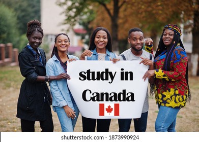 Study in Canada. Group of five african college students on campus at university yard hold white blank. Abroad countries for student concept.