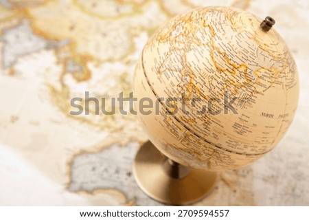 Study globe placed on a detailed world map showcasing various countries and regions