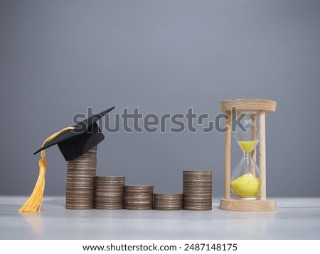Study goals, Hourglass and stack of coins with graduation hat. The concept of saving money for education, student loan, scholarship, tuition fees