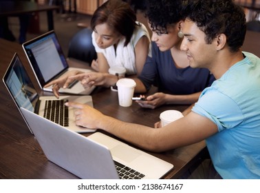 Study Group Dynamics. A Group Of Students Using A Laptop To Complete A Group Assignment.