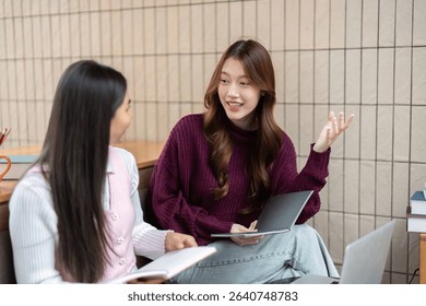 Study Session and Collaboration. Two students discussing notes and sharing ideas in a study space.