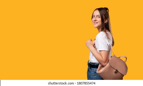 Study Time. Student Lifestyle. Smiling Young Woman With Backpack Isolated On Orange Copy Space. High School. Practical Training. Knowledge And Skills