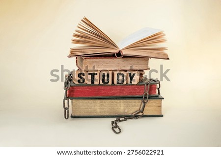 Study will set you free, still life concept with stacked  books and broken chains, on beige background

