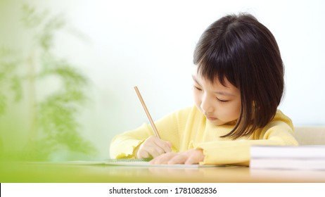 Studying Asian Little Schoolgirl In Classroom. Education Concept.