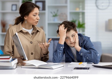 Studying at home, home teacher woman explaining school material to boy student, home school sitting in living room among books. - Powered by Shutterstock