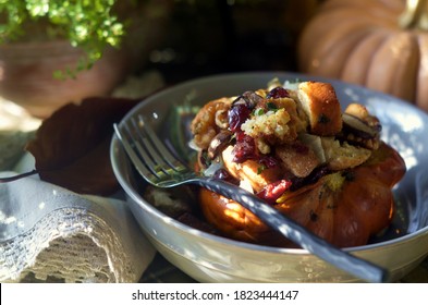 Stuffed Acorn Squash With Sausage, Dried Cranberries, Mushrooms, Sourdough Croutons, Walnuts And Sage.  Autumn Decorations Surround Dish, With Napkin Trimmed With Lace To Left.