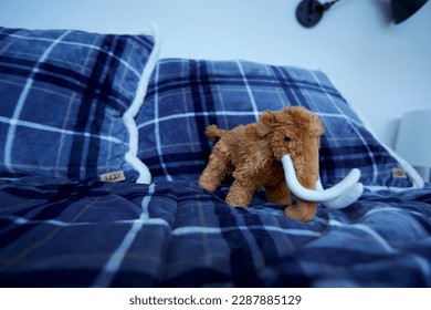 stuffed animal mammoth on bed