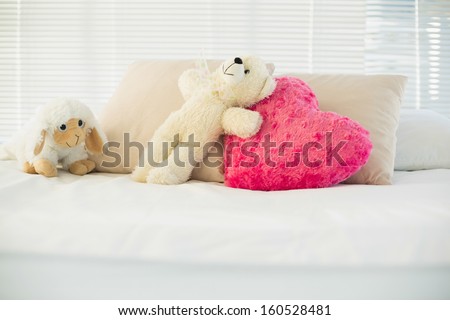 Stuffed animals and a heart pillow lying on couch in living room