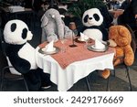 Stuffed animals sitting at a table, having a lunch party