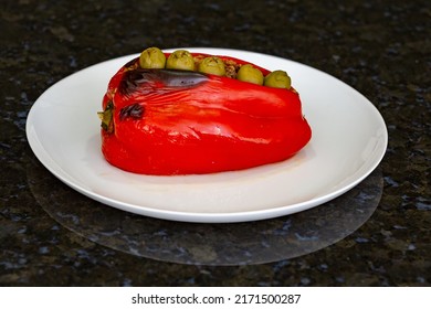 Stuffed And Baked Red Peppers In The Oven, On The White Plate Alone And In Selective Focus