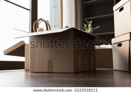 Stuffed cardboard boxes with packed personal belongings stacked on floor in living room on relocation day or move-out, no people. Bank mortgage, start new life, first own or rented house, investment