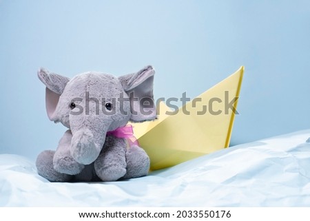 stuffed elephant in a paper boat at sea. Children's concept, 
