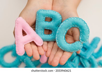 Stuffed Felt Letter Of The Alphabet In Open Hands Of Child. Kid Holding  Handmade Capital Letters 