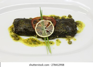 Stuffed Flounder Grape Leaves Served In A White Plate.