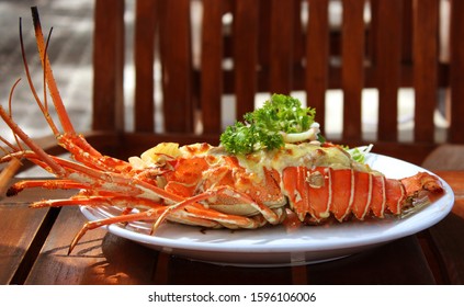 Stuffed Lobster On A White Plate On A Wooden Table In The Garden