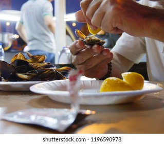 stuffed mussels and man squeeze lemon. midye dolma in Turkish language