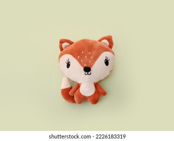 Stuffed orange toy fox on green background