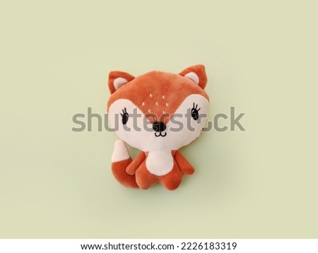 Stuffed orange toy fox on green background