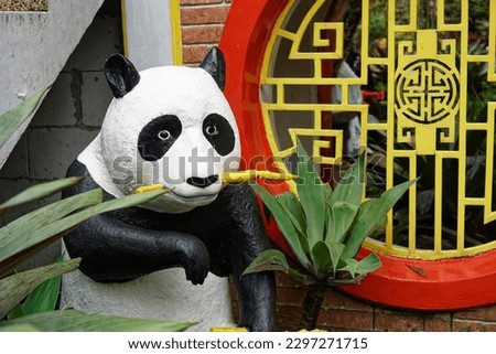 a stuffed panda statue eating bamboo